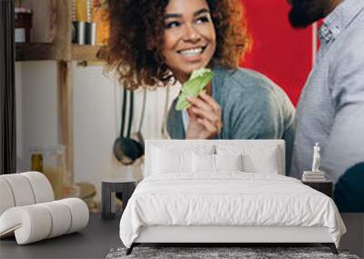 Vegetarian african-american couple cooking salad in kitchen Wall mural