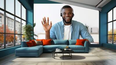 Videocall screenshot of happy young black man in headset having web conference Wall mural