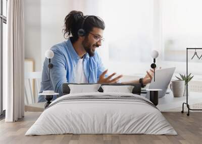 Web Conference. Arabic Freelancer Guy In Headset Making Video Call On Laptop Wall mural