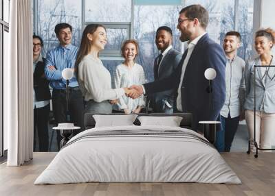 Welcome! Boss and woman shaking hands in office Wall mural