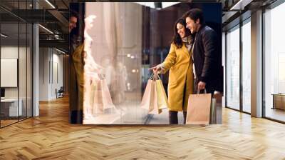 Window shopping. Couple looking at fashion store's showcase Wall mural