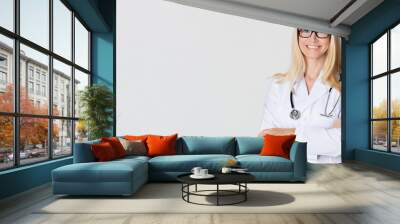 Woman doctor with stethoscope posing on grey background Wall mural