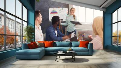 Woman giving presentation to colleagues in office Wall mural