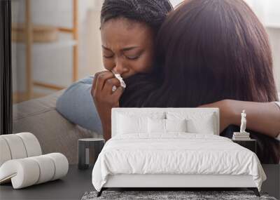 Woman hugging her crying girlfriend, supporting her after receiving bad news Wall mural