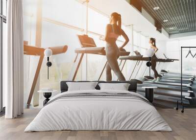 Woman running on treadmill at panoramic window Wall mural