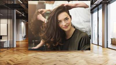 Woman sitting at beauty salon, making hairdo Wall mural