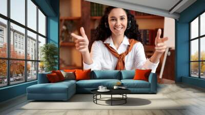 Woman sitting at desk, talking to camera wearing headset Wall mural