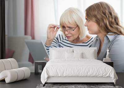 Woman teaching senior woman to use tablet computer Wall mural