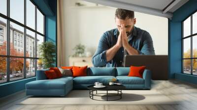 worried middle aged man at laptop suffering from stress indoor Wall mural