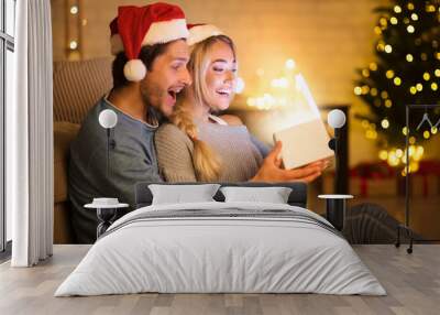 Wow! Surprised Christmas couple opening magical gift box Wall mural