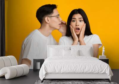 Young asian guy telling exciting news to his lover Wall mural