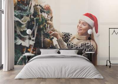 Young beautiful woman decorating christmas tree, new year decora Wall mural