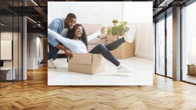 Young man pushing box with his woman, moving in Wall mural