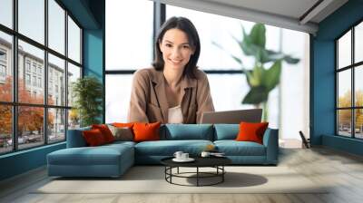 Young manager smiling at camera in modern office Wall mural