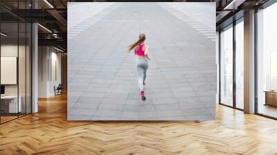 Young woman running in city copy space Wall mural