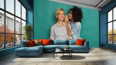 Young woman telling her friend some secrets Wall mural