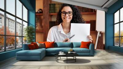 Young woman with glasses pointing to a sheet of paper Wall mural