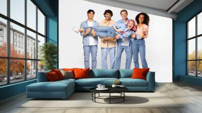 Youth and fun. Group of excited multiracial students holding friend and smiling at camera, white background, full length Wall mural