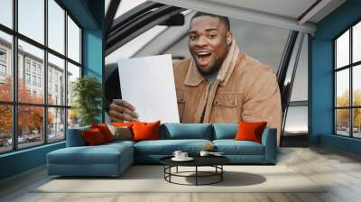 Black man with happy face impression holding sheet of paper Wall mural