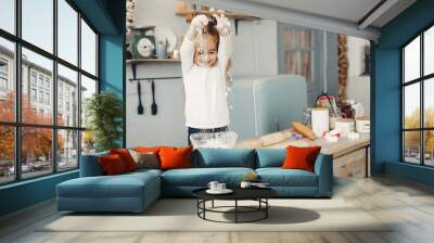 Child in a kitchen. Little girl with a dough. Wall mural