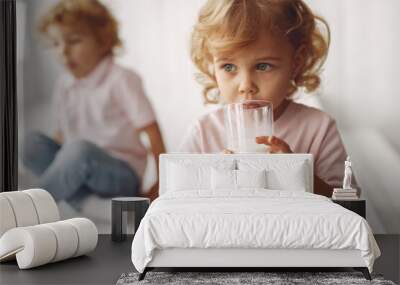 Children in a studio. Little girl with her brother. Boy in a pink t-shirt. Kids drinking a milk. Wall mural