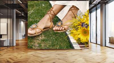 Close up of muslim woman hands tying her open summer sandals shoes Wall mural