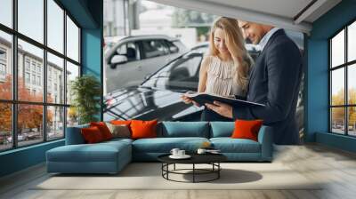 Couple in a car salon. Family buying the car. Elegant woman with her boyfriend Wall mural