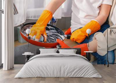 Cropped photo of two pair of hands washing a frying pan in a kitchen Wall mural