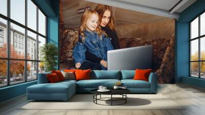 Cute family at home. Beautiful mother use the laptop with her daughter. Wall mural