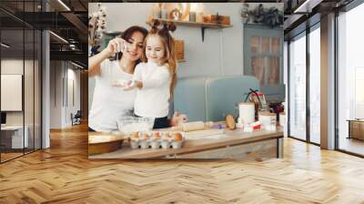 Family in a kitchen. Beautiful mother with little daughter Wall mural