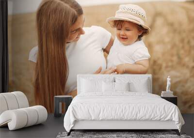 Family in a summer field. Mother in a white t-shirt. Cute little girl Wall mural