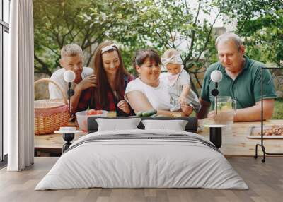 Family sitting in the yard. Mother and little daughter near the house. Big family on a picnic Wall mural