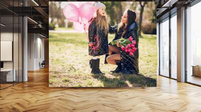 Fashionable mother with daughter. Family in a spring park. Mother's day Wall mural