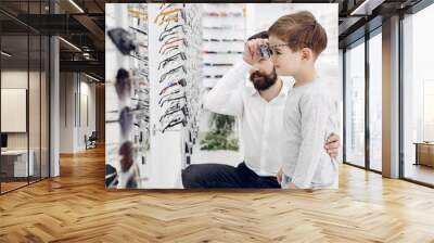 Father with cute son. Family buy glasses Wall mural