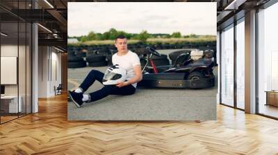 Karting. Man in a white t-shirt. Male with a kart car Wall mural