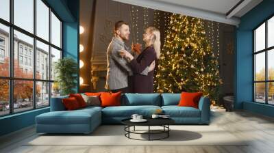 Man and woman dancing near Christmas tree while celebrating New Year Wall mural