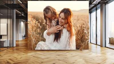 Mother with daughter playing in a summer field Wall mural