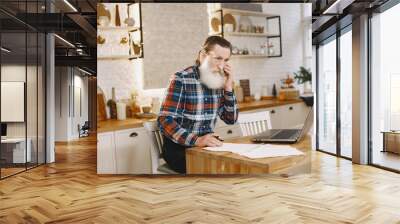 Old man with laptop. Grandfather sitting in a Christmas decorations. Man with mobile phone. Wall mural