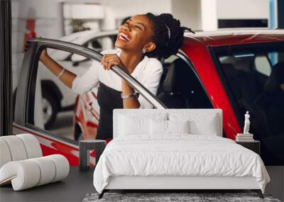 Woman buying the car. Lady in a car salon. Elegant black girl Wall mural