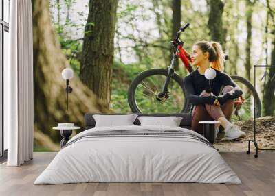 Woman riding a mountain bike in the forest Wall mural