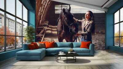 Woman standing with a horse. Lady in a brown jacket Wall mural