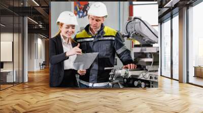 2 young successful engineer discussing the technical documentation. girl engineer in a white helmet  Wall mural