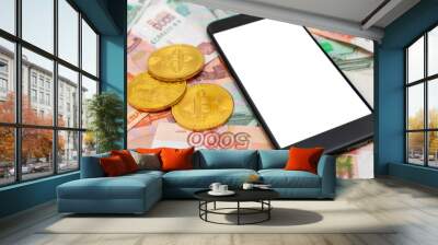 A black smartphone with a white screen lies on rubles and bitcoin. Russian money. Wall mural