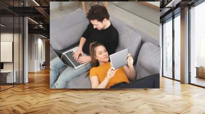 Couple using home internet with mobile devices Wall mural