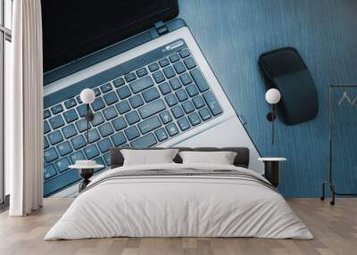 Laptop and modern flat mouse on wooden desk Wall mural