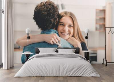 New home owners with keys, happy woman hugs Wall mural