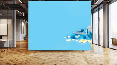 stethoscope and pills on blue background copy space Wall mural