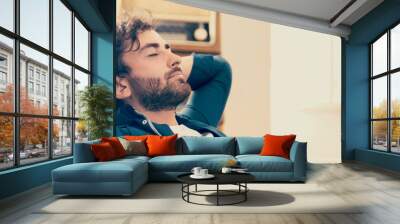 Young man relaxing in his chair Wall mural