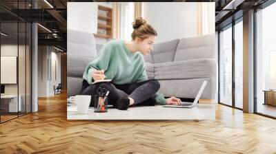 Young student learns at home on the floor Wall mural