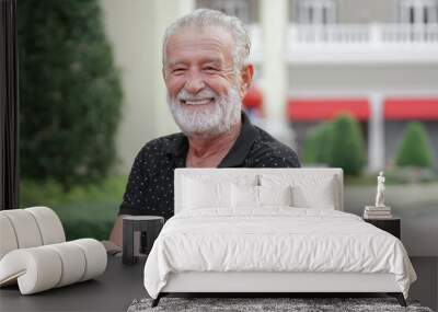 Portrait of happy Caucasian senior kind man with winkles and white beard mustache hairs. Old man is smiling at amusement park Wall mural